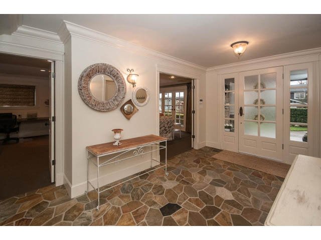 Bright entryway with stone flooring, wooden bench, and decorative mirrors. - 840 16th East St, North Vancouver
