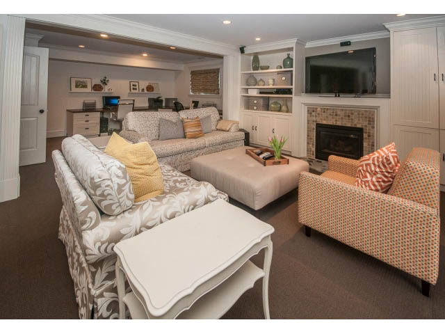 Spacious living room with patterned furniture, fireplace, and flat-screen TV. - 840 16th East St, North Vancouver