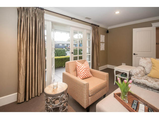 Furnished living room with patterned armchairs, large windows, and a cozy ambiance. - 840 16th East St, North Vancouver