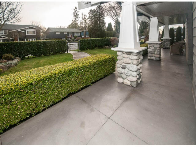 Furnished patio with stone pillars and manicured hedges. - 840 16th East St, North Vancouver