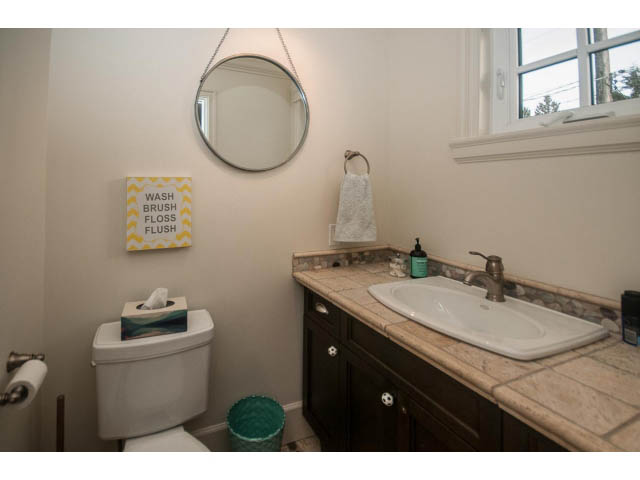 Bright bathroom with wooden cabinets and marble countertops. - 840 16th East St, North Vancouver
