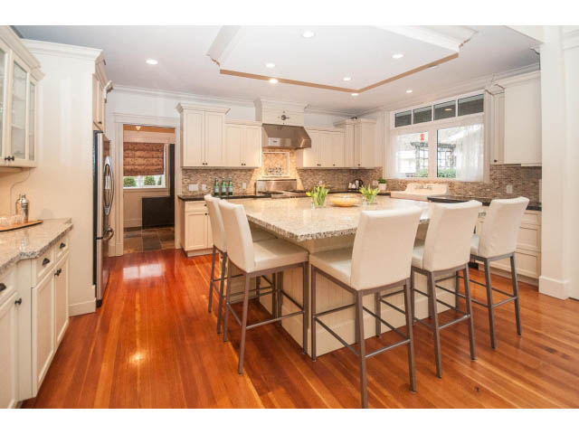 Bright kitchen with white cabinets, granite countertops, and hardwood floors. - 840 16th East St, North Vancouver