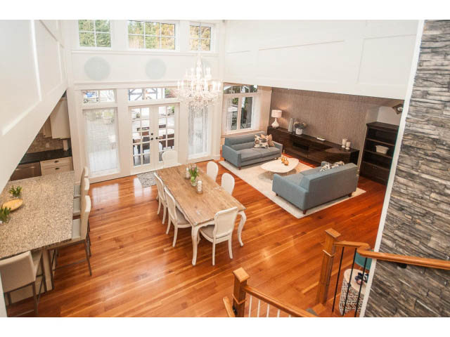 Spacious living room with hardwood floors, granite countertops, and a chandelier. - 840 16th East St, North Vancouver