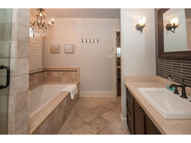 Spacious bathroom with marble countertops and a chandelier. - 840 16th East St, North Vancouver