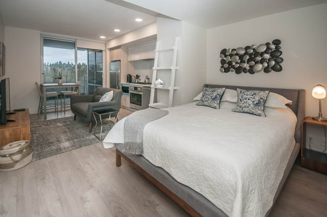 Bright bedroom with modern decor, hardwood floors, and a city view. - 907 - 680 Seylynn Crescent, North Vancouver