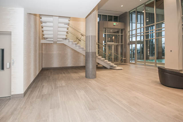 Furnished living room with hardwood floors and a modern staircase. - 907 - 680 Seylynn Crescent, North Vancouver