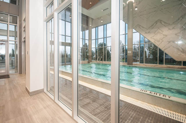 Spacious living room with large windows, hardwood floors, and a modern design. - 907 - 680 Seylynn Crescent, North Vancouver