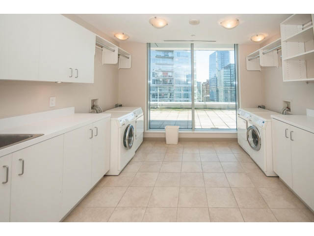 Bright laundry room with white cabinets, countertop, and city view. - 2200 - 1169 W Cordova St, Vancouver Downtown