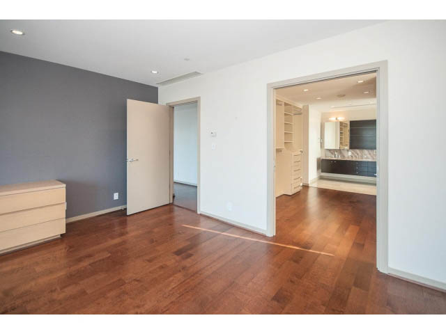 Bright open-concept living room with hardwood floors and a kitchen in the background. - 2200 - 1169 W Cordova St, Vancouver Downtown