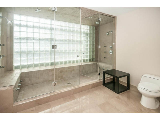 Spacious bathroom with glass block wall, modern fixtures, and sleek black vanity. - 2200 - 1169 W Cordova St, Vancouver Downtown