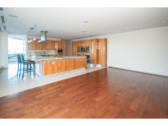 Bright kitchen with wooden countertops and hardwood floors, open to a spacious living area. - 2200 - 1169 W Cordova St, Vancouver Downtown