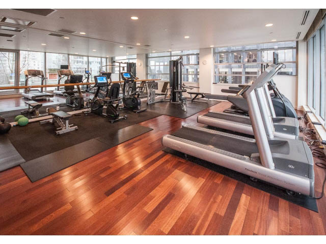 Spacious gym with hardwood floors, cardio machines, and city view windows. - 2200 - 1169 W Cordova St, Vancouver Downtown