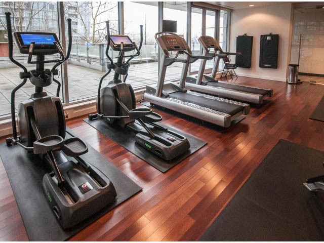 Bright and spacious gym with hardwood floors, cardio machines, and city view windows. - 2200 - 1169 W Cordova St, Vancouver Downtown