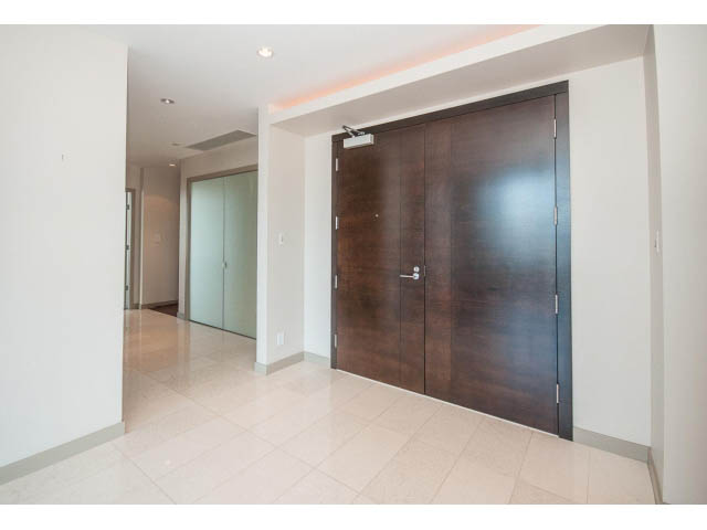 Spacious living room with modern dark wood doors and light tile flooring. - 2200 - 1169 W Cordova St, Vancouver Downtown