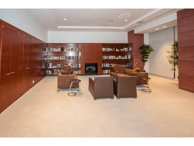 Spacious living room with bookshelves, modern furniture, and a cozy fireplace. - 2200 - 1169 W Cordova St, Vancouver Downtown
