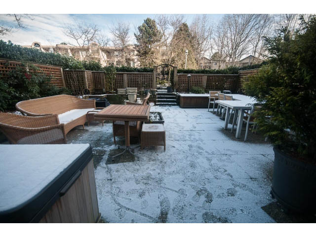 Furnished patio with snow, wooden furniture, and garden view. - 108 - 456 Moberly Rd, Vancouver West Side