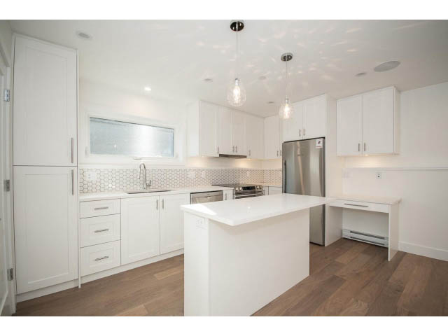 Bright kitchen with white cabinets, hardwood floors, and a modern island. - 4216 W 10th Ave, Vancouver West Side