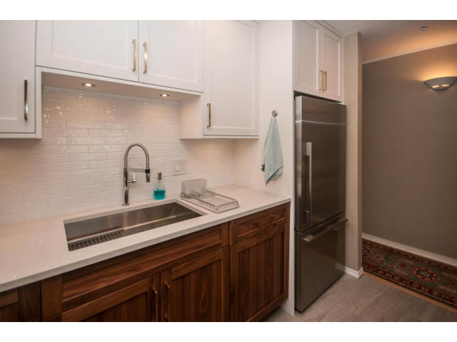 Bright kitchen with white subway tile backsplash, wooden cabinets, and stainless steel appliances. - 301 - 2288 Laurel St, Vancouver West Side