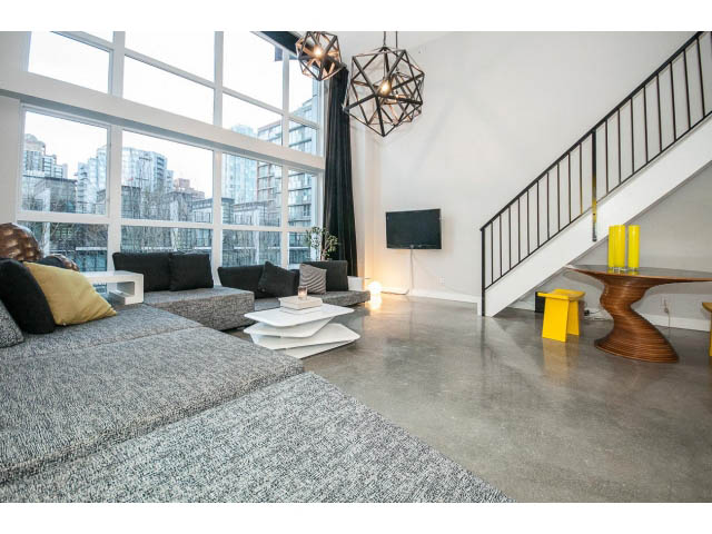 Bright living room with city view, modern decor, and concrete floors. - 307 - 1238 Seymour Street, Vancouver Downtown