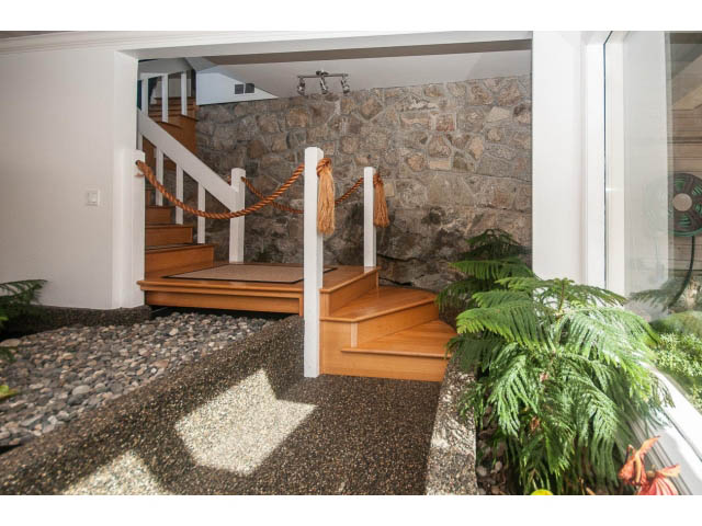 Staircase leading to upper level with stone wall and rope railing. - 3855 Bayridge Ave, West Vancouver