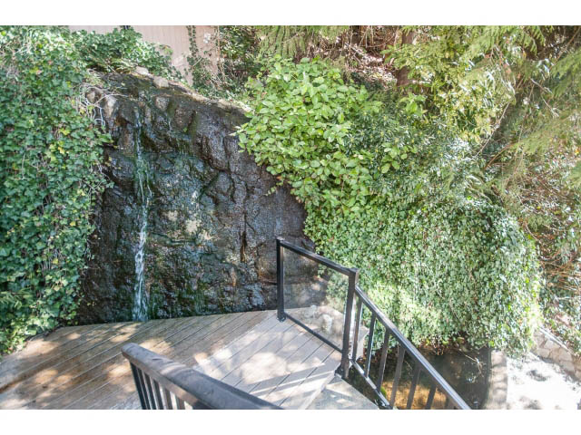 Furnished deck with wooden stairs and ivy-covered wall. - 3855 Bayridge Ave, West Vancouver