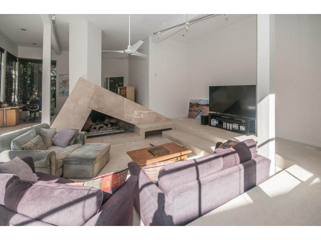 Spacious living room with modern furniture, large windows, and a cozy fireplace. - 3855 Bayridge Ave, West Vancouver