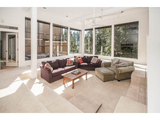 Bright living room with large windows, modern furniture, and natural light. - 3855 Bayridge Ave, West Vancouver