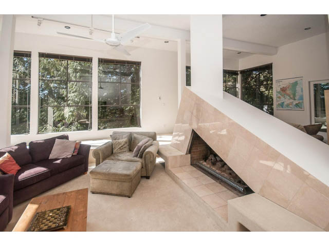Spacious living room with large windows, modern furniture, and a cozy ambiance. - 3855 Bayridge Ave, West Vancouver