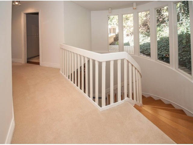 Bright living room with carpeted floors and large windows overlooking a garden. - 3855 Bayridge Ave, West Vancouver