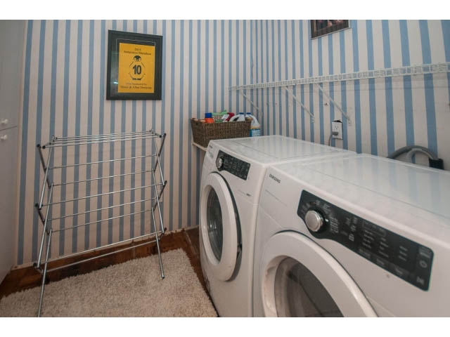 Laundry room with striped wallpaper, washing machine, drying rack, and wall shelf. - 3855 Bayridge Ave, West Vancouver