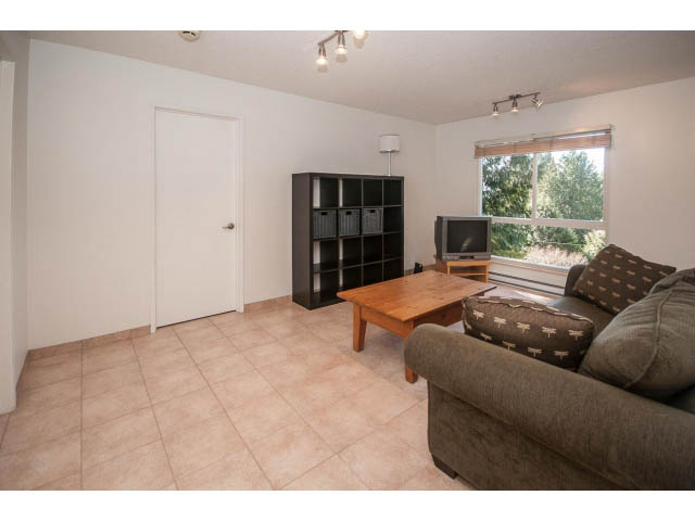 Bright living room with tiled floors, large window, and modern furniture. - 3855 Bayridge Ave, West Vancouver