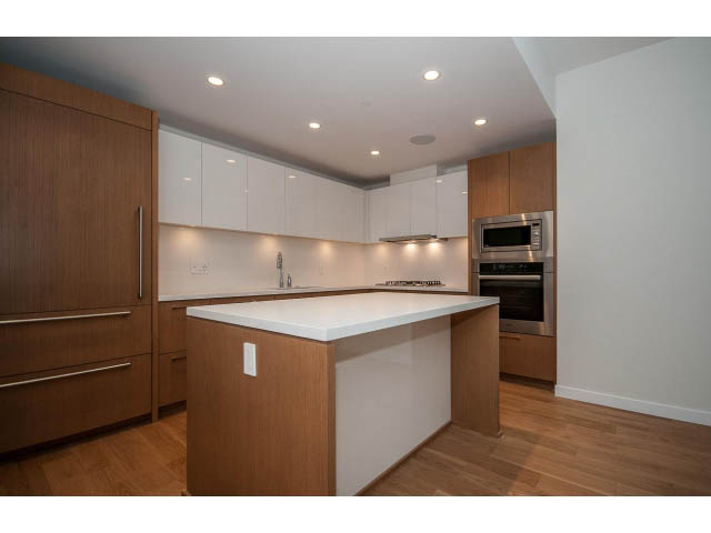 Bright kitchen with white countertops, hardwood floors, and modern appliances. - 204 - 788 Arthur Erickson Pl, West Vancouver