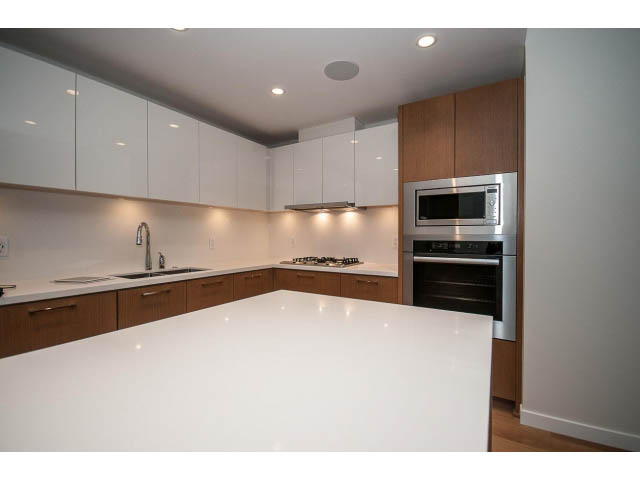 Bright kitchen with white countertops, stainless steel appliances, and wooden cabinets. - 204 - 788 Arthur Erickson Pl, West Vancouver