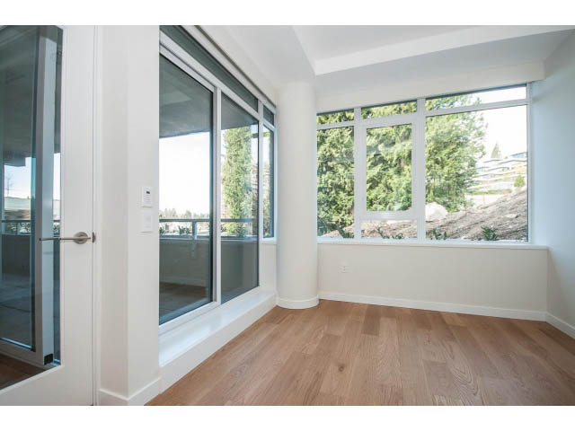 Bright living room with hardwood floors and city view. - 204 - 788 Arthur Erickson Pl, West Vancouver