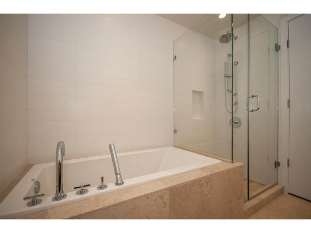Furnished bathroom with marble countertops and glass shower enclosure. - 204 - 788 Arthur Erickson Pl, West Vancouver