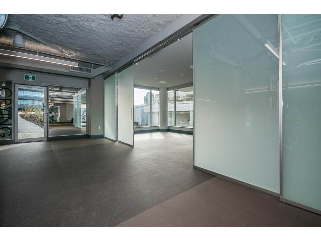 Spacious open-concept living room with large windows and modern decor. - 204 - 788 Arthur Erickson Pl, West Vancouver