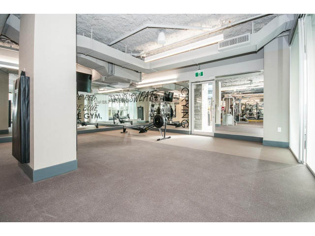 Spacious living room with modern furniture and large windows. - 204 - 788 Arthur Erickson Pl, West Vancouver