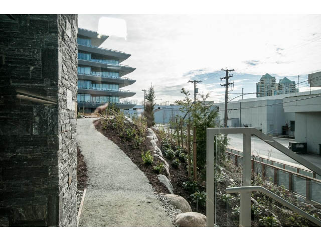 Furnished 2-bedroom + den with stone walls, concrete pathways, and city views. - 204 - 788 Arthur Erickson Pl, West Vancouver