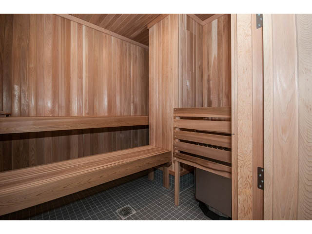 Furnished den with wooden paneling and built-in shelves. - 204 - 788 Arthur Erickson Pl, West Vancouver