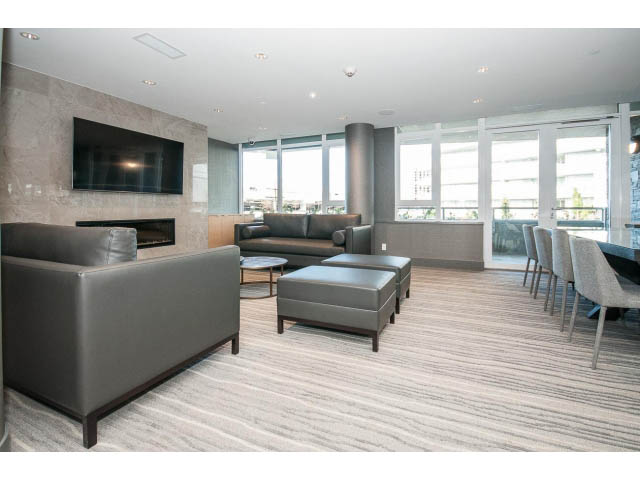 Furnished living room with large windows, modern furniture, and a city view. - 204 - 788 Arthur Erickson Pl, West Vancouver