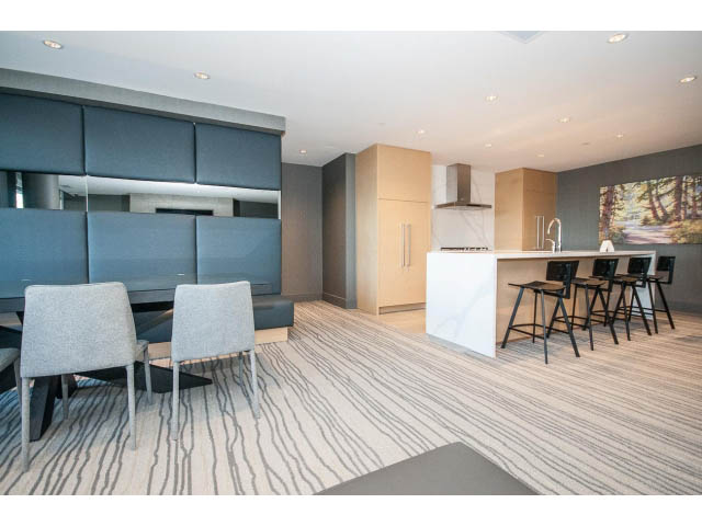 Furnished living room with modern furniture, large windows, and a cozy ambiance. - 204 - 788 Arthur Erickson Pl, West Vancouver