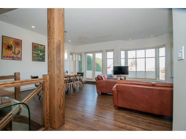 Furnished living room with hardwood floors, large windows, and modern decor. - 3131 Collingwood St, Vancouver West Side