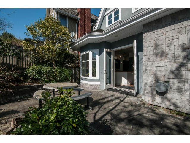 Bright living room with stone walls and open door leading to patio. - 3131 Collingwood St, Vancouver West Side