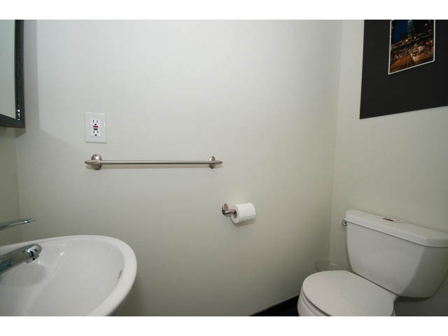 Bathroom with white sink, toilet, and grab bars. - 3131 Collingwood St, Vancouver West Side