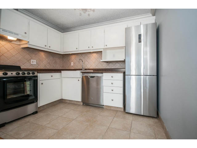 Bright kitchen with white cabinets, stainless steel appliances, and tiled backsplash. - 1604 - 145 St Georges Ave, North Vancouver