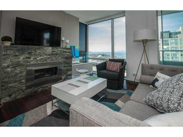 Bright living room with city view, modern fireplace, and comfortable furnishings. - 2404 - 1500 Hornby St, Vancouver Downtown