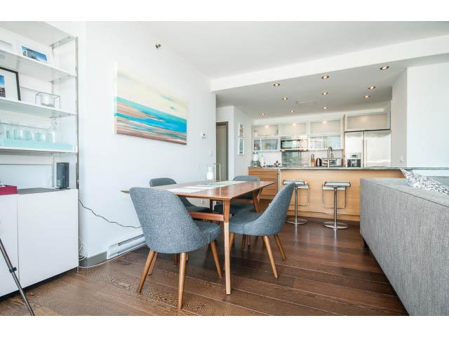 Bright dining area with modern chairs, wooden table, and white cabinets. - 2404 - 1500 Hornby St, Vancouver Downtown