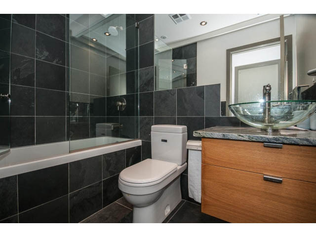 Bathroom with dark tiles, modern sink, and wooden vanity. - 2404 - 1500 Hornby St, Vancouver Downtown