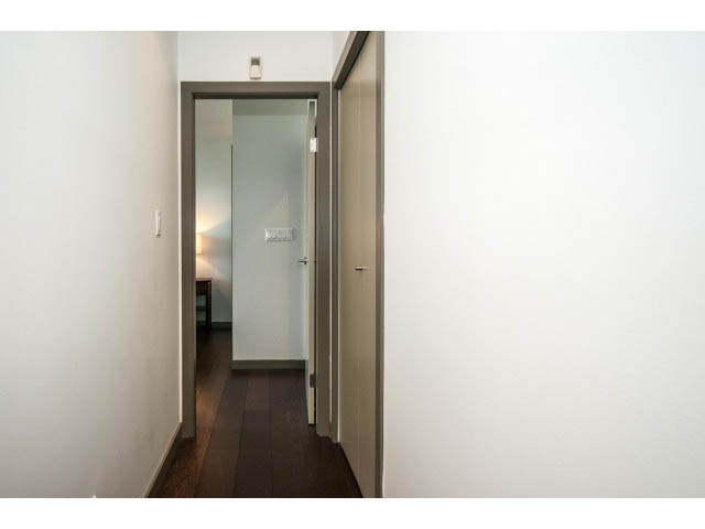 Framed hallway leading to a door, white walls, dark flooring. - 2404 - 1500 Hornby St, Vancouver Downtown