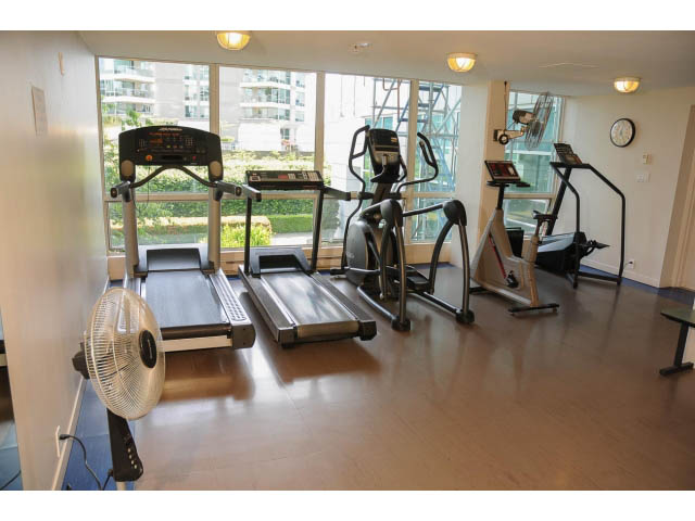 Bright fitness room with hardwood floors, city view, and modern equipment. - 2404 - 1500 Hornby St, Vancouver Downtown